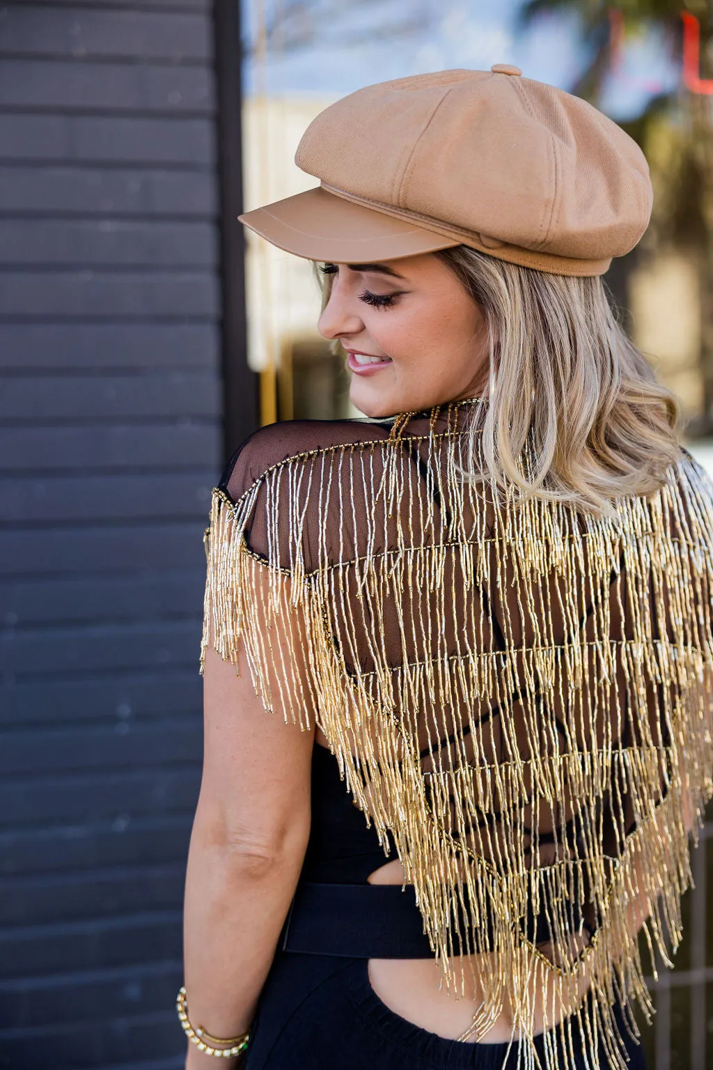 A gold hand-beaded Edge of Ether cape, seen from behind